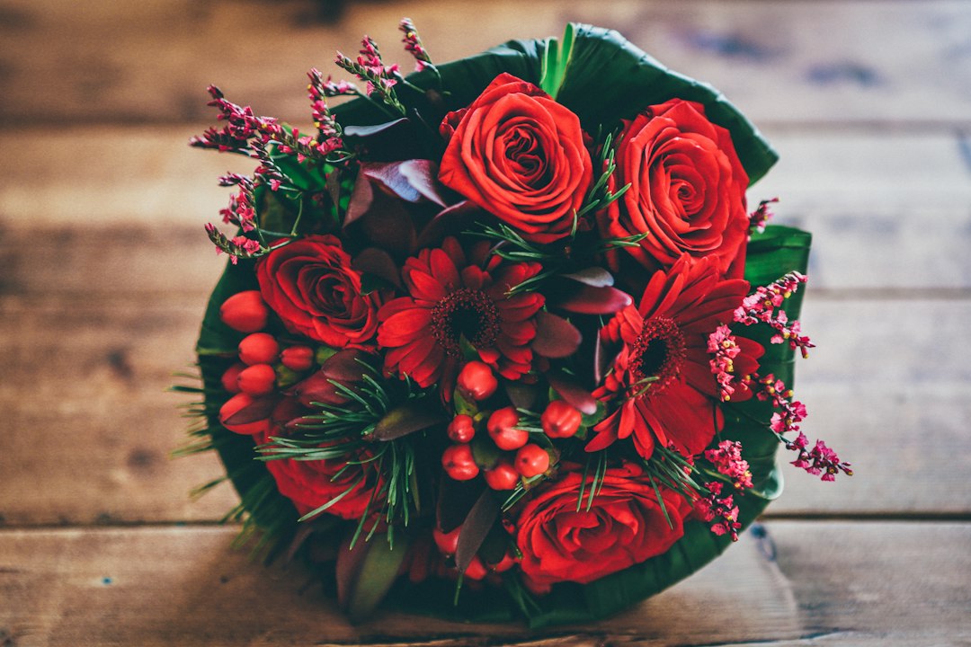 hoa tặng sinh nhật - red flower bouquet on brown surface (Unsplash: Nick Karvounis)